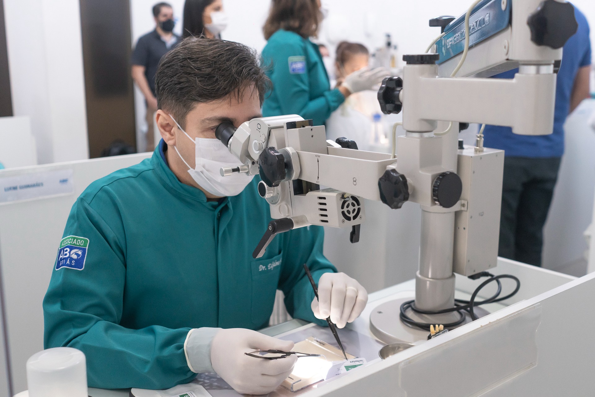 Aluno em prática com microscópio odontológico